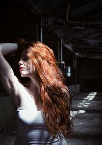 Side view of young woman standing in corridor