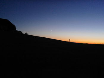 Silhouette of building against clear sky during sunset