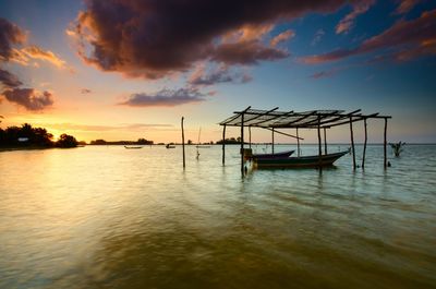 Silhouette of sailboat in sea against sky during sunset