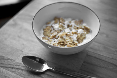 High angle view of spoon by cornflakes on table