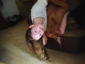 Portrait of dog lying down on floor at home