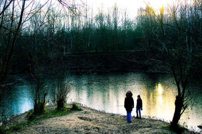 Rear view of man and woman walking by plants