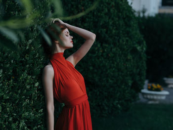 Young woman standing by plants