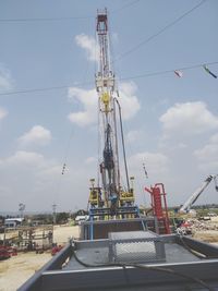 Low angle view of cranes against sky