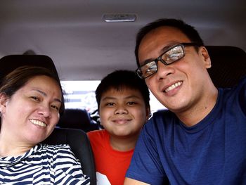 Portrait of smiling family sitting in car