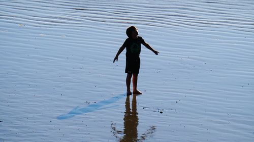 Rear view of woman standing in water