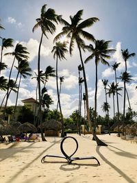 Scenic view of palm trees on beach against sky
