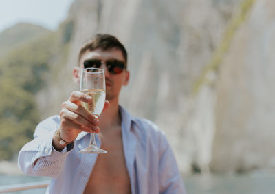 Portrait of a young man drinking champagne in a boat.