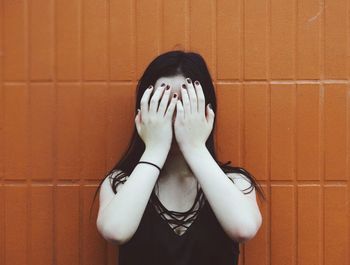Portrait of woman standing against wall