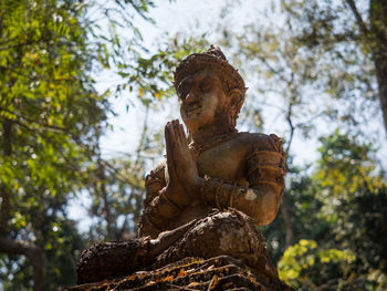 Low angle view of statue against trees