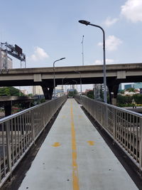 Footbridge over street against sky