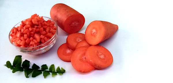 High angle view of chopped fruits on table against white background