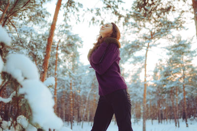 Young woman enjoying winter weather in the snow forest. cold weather. winter holidays, rest