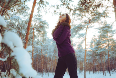 Side view of woman standing in forest