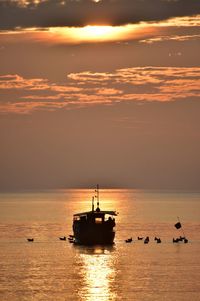 Silhouette sailboat on sea against sky during sunset