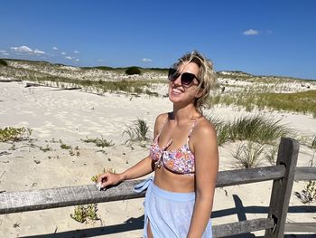 Portrait of young woman wearing sunglasses while standing against mountain