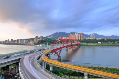 Bridge over city against sky at dusk