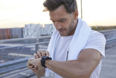 Athlete in the city looking on smartwatch