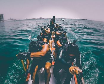 People enjoying in sea against sky