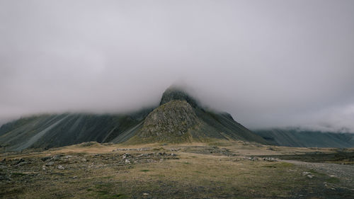 Scenic view of landscape and mountains against sky during foggy weather