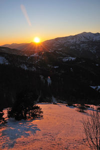 Scenic view of snowcapped mountains against sky during sunset