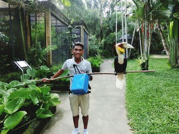 Full length of young man standing against plants