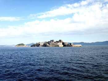 Scenic view of sea by buildings against sky