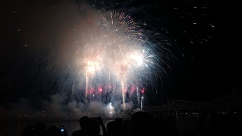 People watching firework display at night