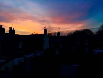 Silhouette buildings against sky during sunset