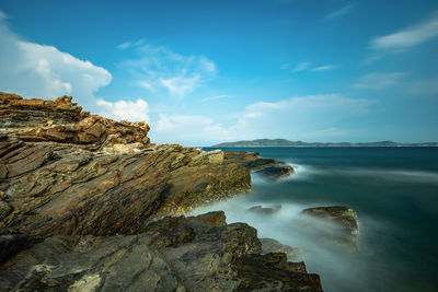 Rock formations on shore against sky