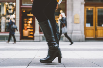 Low section of woman walking on street