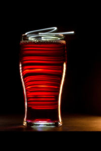 Close-up of beer glass on table against black background