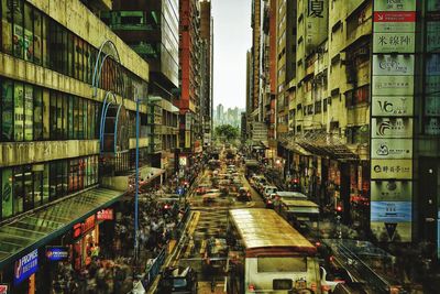 Traffic on road amidst buildings in city