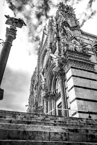 Low angle view of cross against building