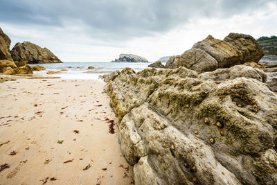 Rocks on beach against sky