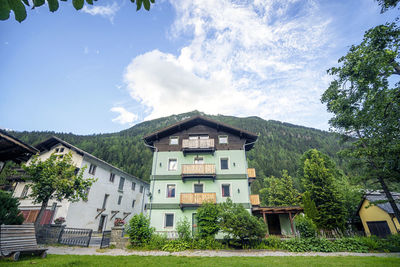 Houses by trees against sky