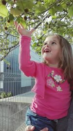 Girl standing against tree