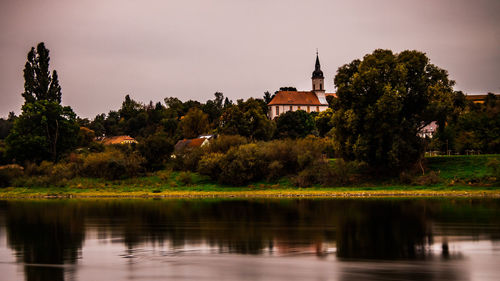 Scenic view of lake by building against sky