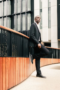 Full length of young man standing against building