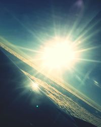 Low angle view of sun shining in sky