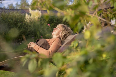 Side view of woman sitting outdoors