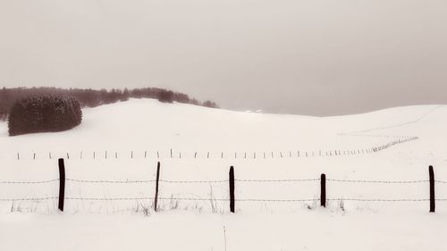 Scenic view of snow covered field against sky