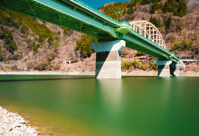 Long exposure of a solid rib arched bridge connecting northern and southern shorelines of lake.