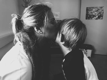 Close-up of mother kissing son at home