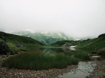 Scenic view of lake and mountains against sky