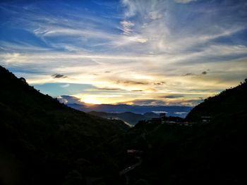 Scenic view of silhouette mountains against sky at sunset