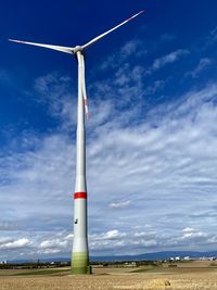 Low angle view of windmill on field against sky