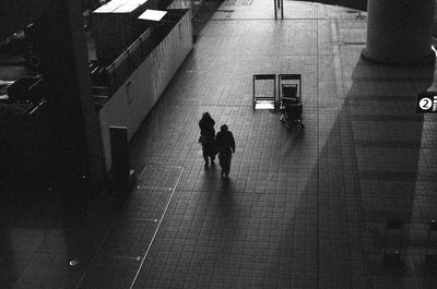 High angle view of silhouette people walking on footpath at night