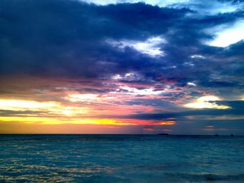 Scenic view of sea against dramatic sky during sunset