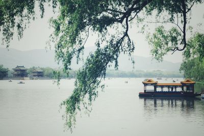 Boats moored on lake against sky